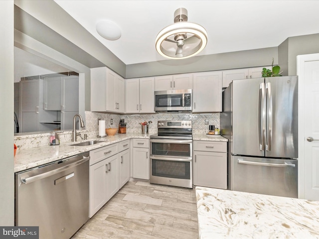 kitchen featuring tasteful backsplash, appliances with stainless steel finishes, sink, and white cabinets