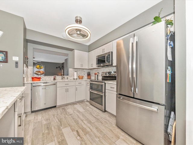 kitchen with white cabinetry, sink, tasteful backsplash, and stainless steel appliances