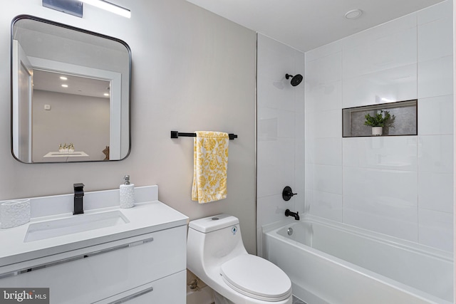 full bathroom with toilet, tiled shower / bath, and vanity