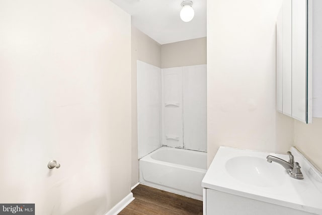 bathroom with hardwood / wood-style flooring, shower / tub combination, and vanity