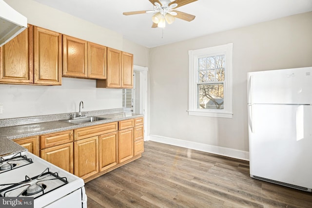 kitchen featuring white appliances, ceiling fan, dark hardwood / wood-style floors, and sink