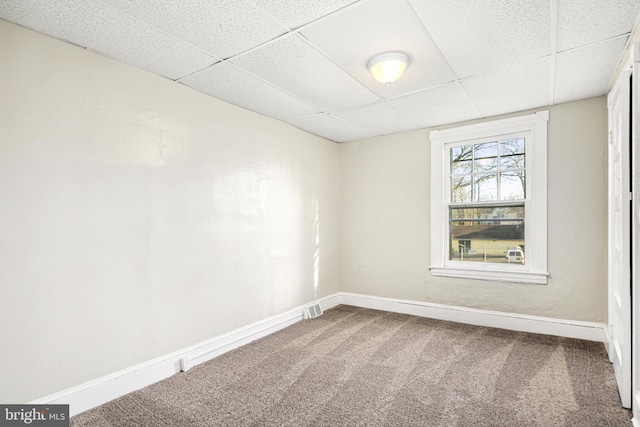 unfurnished room with a paneled ceiling and carpet flooring