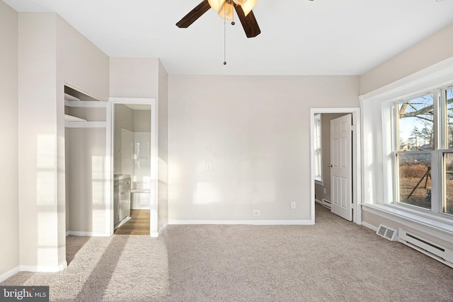 unfurnished bedroom with ceiling fan, a baseboard radiator, carpet flooring, and connected bathroom