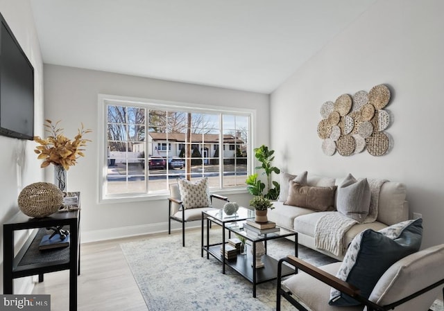 living room featuring light wood-type flooring and lofted ceiling