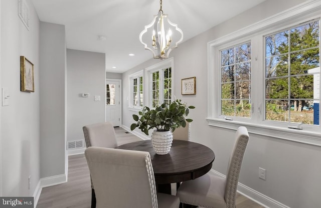 dining space featuring an inviting chandelier and light hardwood / wood-style floors