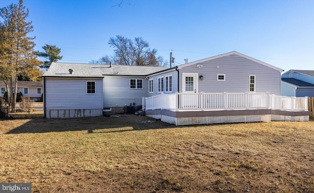 back of property with a lawn, a deck, and cooling unit