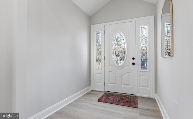 foyer entrance with lofted ceiling and light wood-type flooring