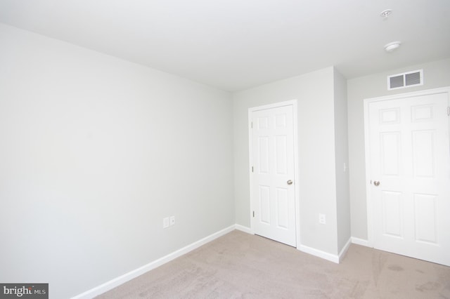 unfurnished bedroom featuring light carpet