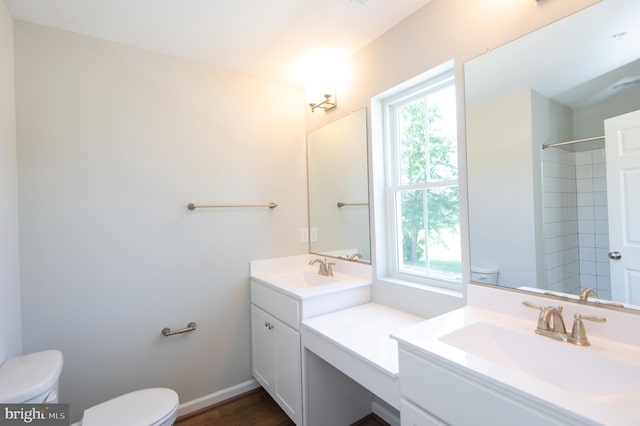 bathroom with wood-type flooring, walk in shower, vanity, and toilet