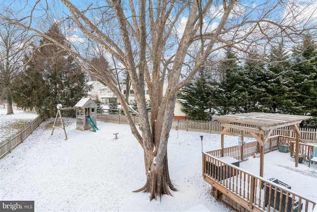 yard layered in snow featuring a playground