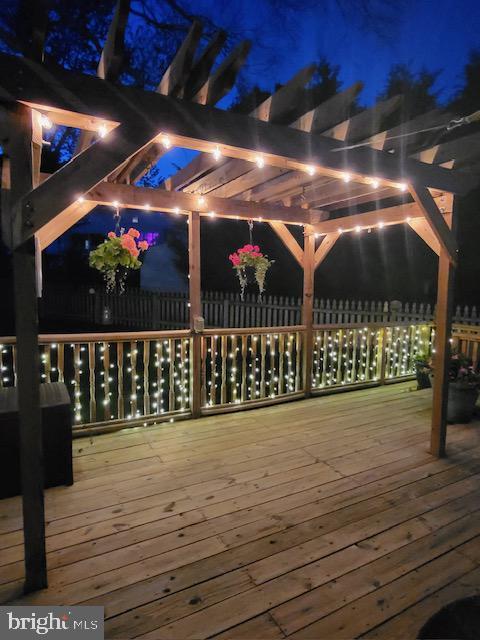 deck at twilight featuring a pergola