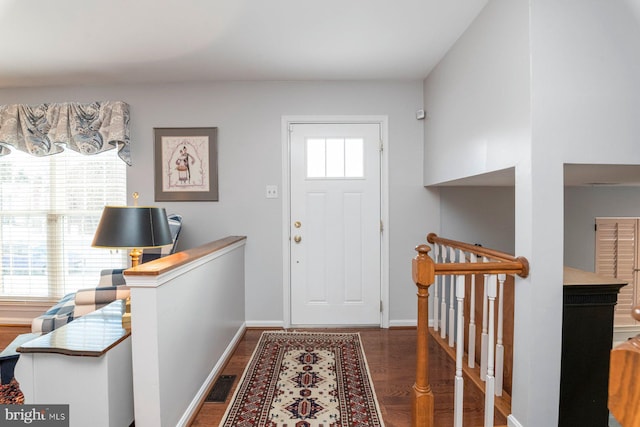 foyer entrance with dark wood-type flooring and a wealth of natural light