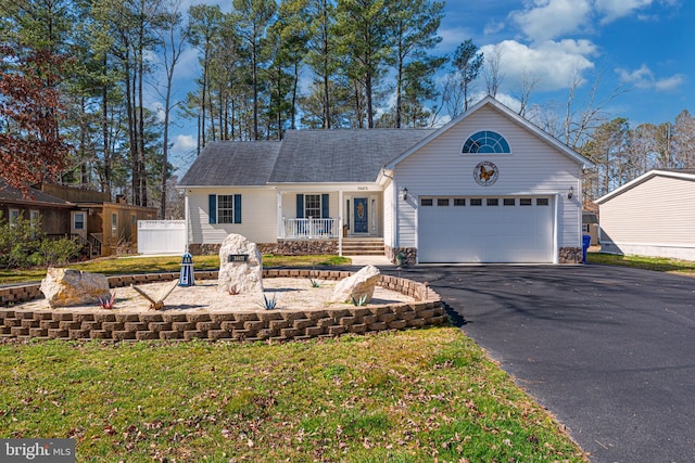 ranch-style house featuring a porch, a front lawn, and a garage