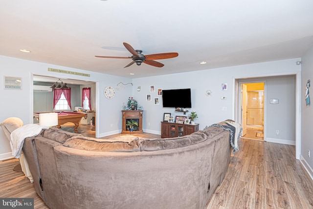 living room featuring light wood-type flooring, ceiling fan, and billiards