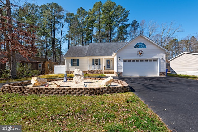 view of front of house featuring a porch, a front lawn, and a garage