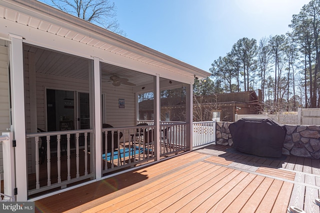 wooden terrace with ceiling fan, a sunroom, and a grill