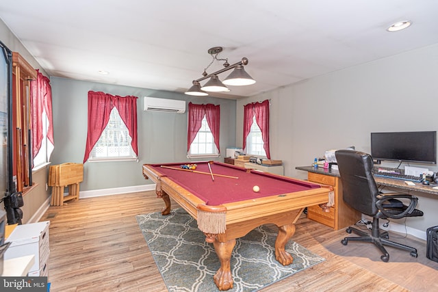 recreation room featuring pool table, light hardwood / wood-style floors, and an AC wall unit