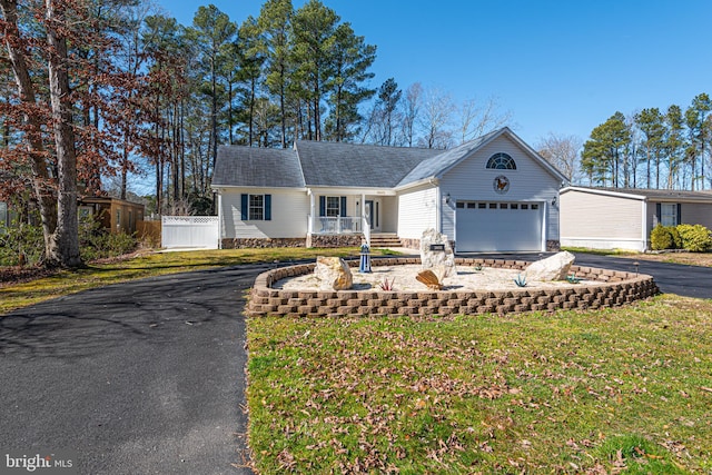 single story home with a front yard, covered porch, and a garage