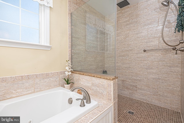 bathroom featuring shower with separate bathtub