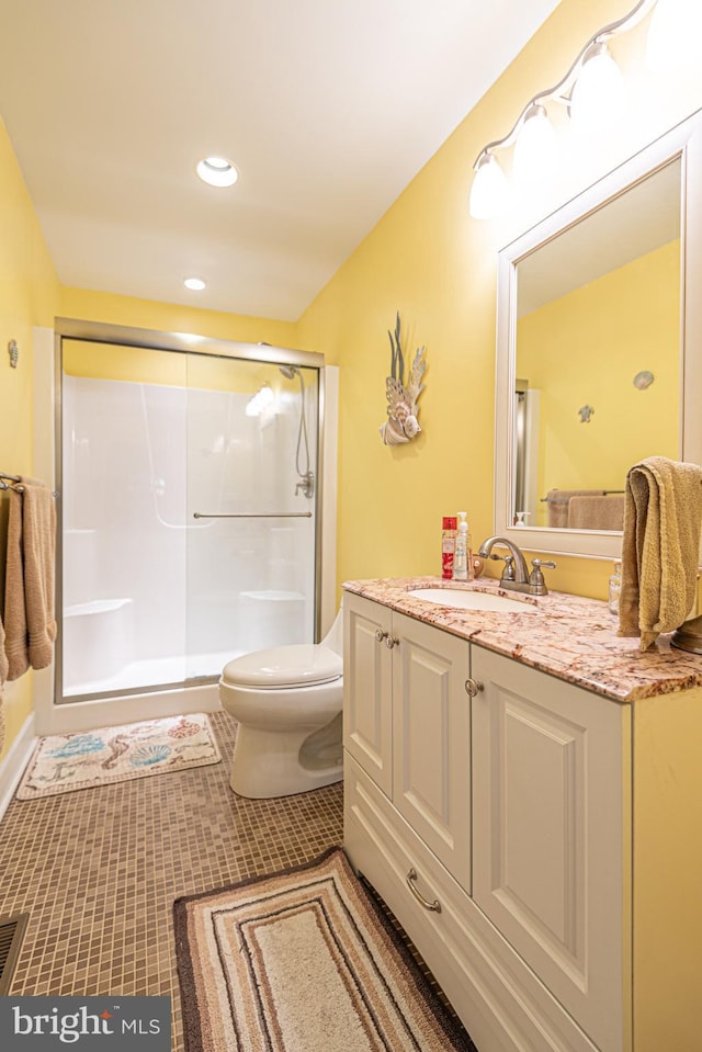 bathroom with toilet, an enclosed shower, tile patterned floors, and vanity