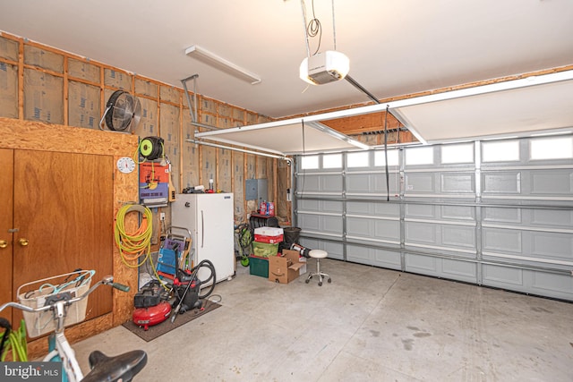 garage featuring white refrigerator and a garage door opener