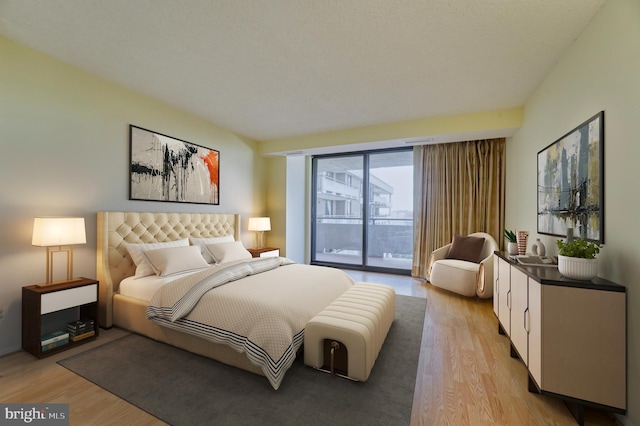 bedroom featuring light wood-type flooring and access to outside