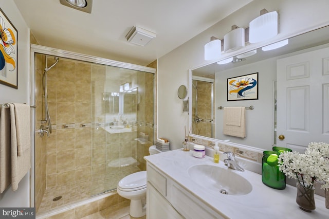 bathroom with a shower with door, vanity, and toilet