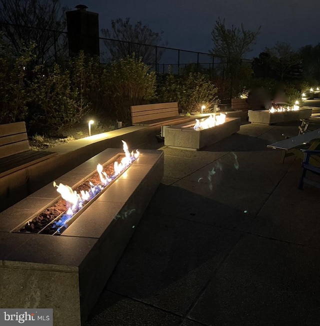 patio at night featuring a fire pit