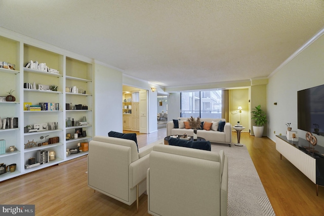 living room with ornamental molding, wood-type flooring, and a textured ceiling