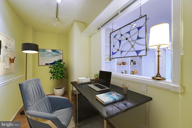 office featuring wood-type flooring, rail lighting, and a textured ceiling