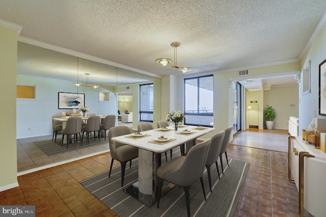 dining room featuring crown molding, a textured ceiling, and dark tile patterned floors