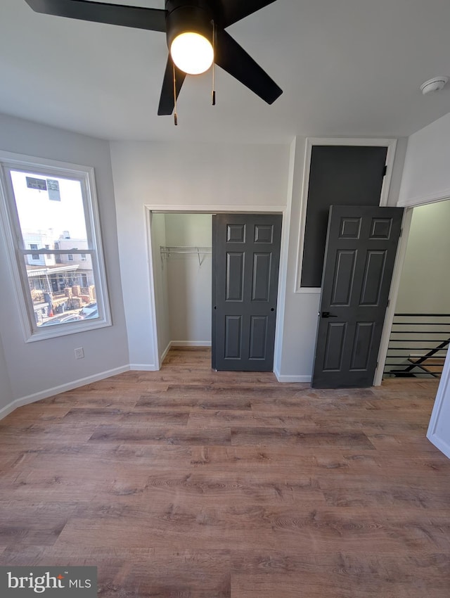 unfurnished bedroom featuring ceiling fan, a closet, and light hardwood / wood-style flooring