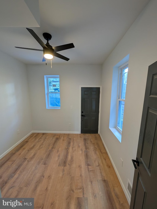 unfurnished room featuring ceiling fan, a wealth of natural light, and light hardwood / wood-style floors