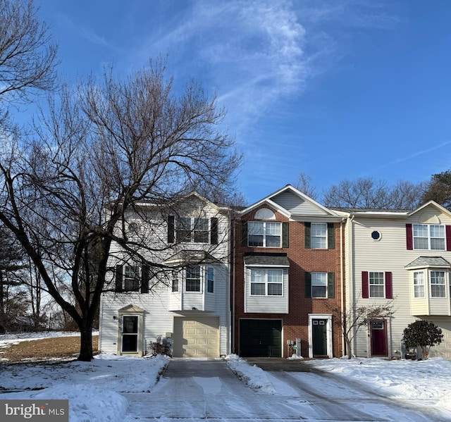 townhome / multi-family property featuring a garage and brick siding