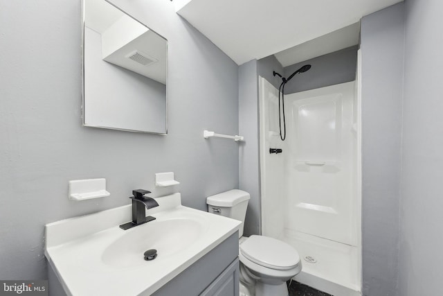 bathroom featuring vanity, a shower, and toilet