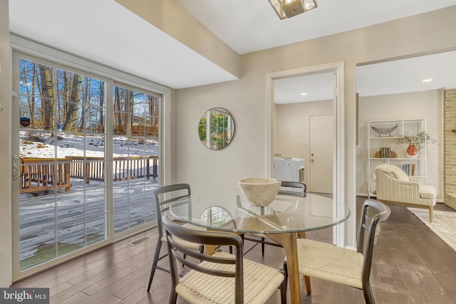 dining space with wood-type flooring and washer and clothes dryer