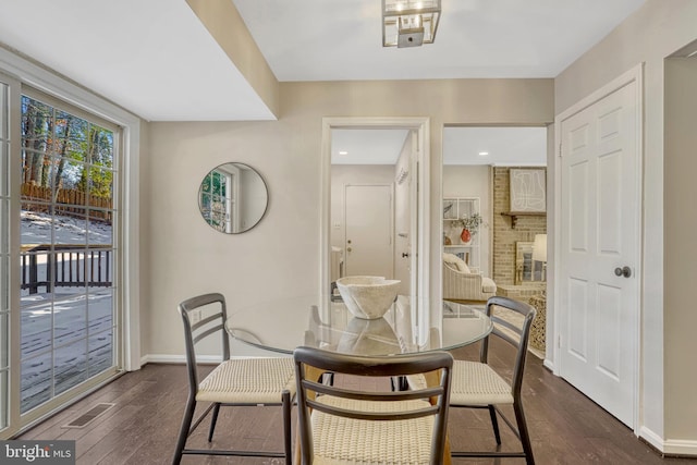 dining area featuring a fireplace and dark hardwood / wood-style flooring