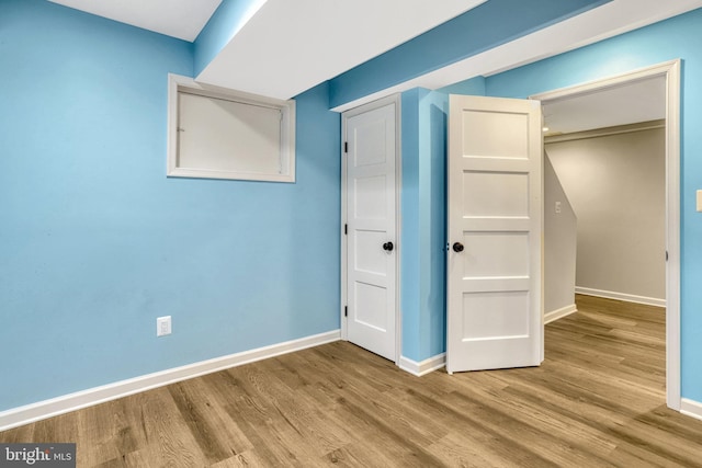 unfurnished bedroom featuring hardwood / wood-style floors and a closet