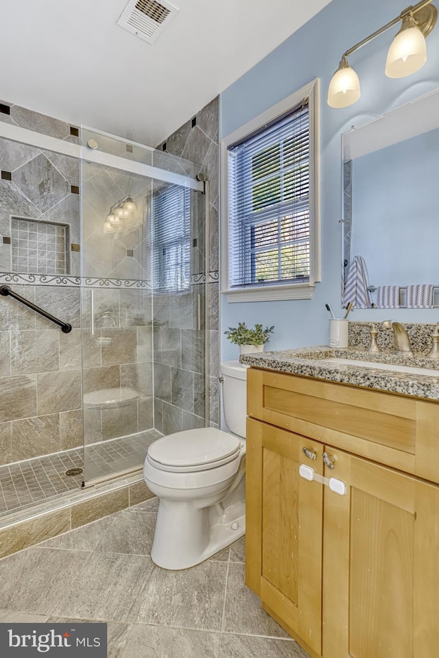 bathroom with walk in shower, vanity, toilet, and tile patterned flooring