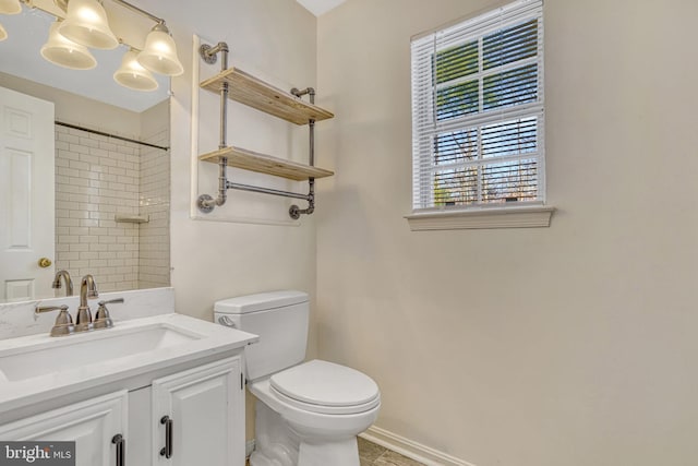 bathroom featuring vanity, toilet, and a tile shower