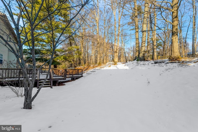 yard layered in snow featuring a deck