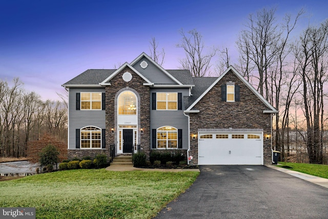 view of front of home with a garage and a lawn