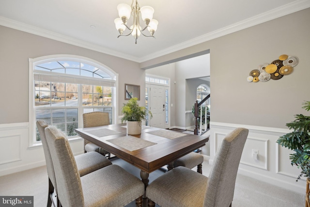 carpeted dining space featuring ornamental molding and a chandelier