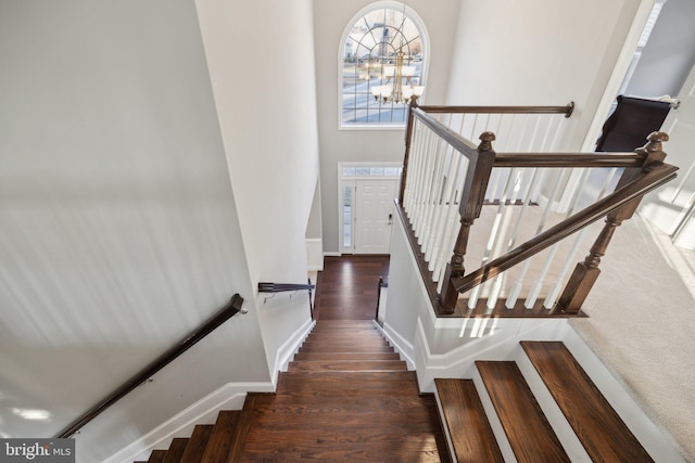 stairs with hardwood / wood-style flooring and a chandelier