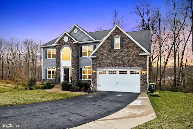 view of front of house featuring a garage and a lawn