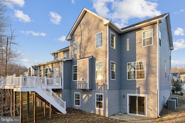 back of property with a deck and central air condition unit