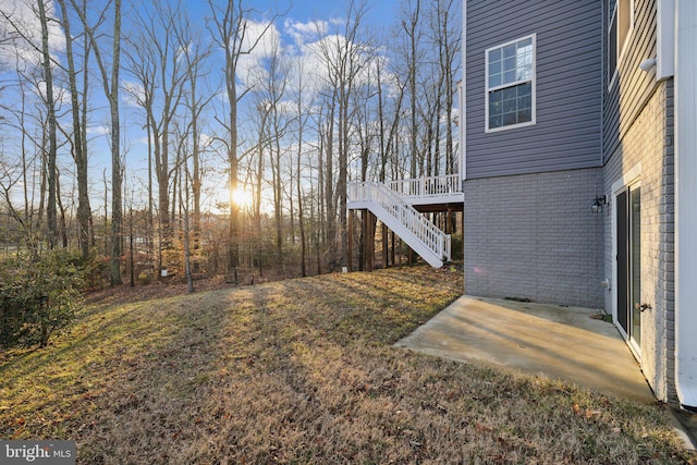 view of yard featuring a wooden deck and a patio area