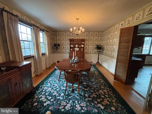 dining room with light hardwood / wood-style floors and an inviting chandelier