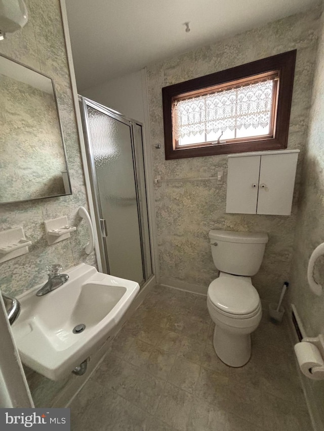 bathroom with toilet, walk in shower, and sink