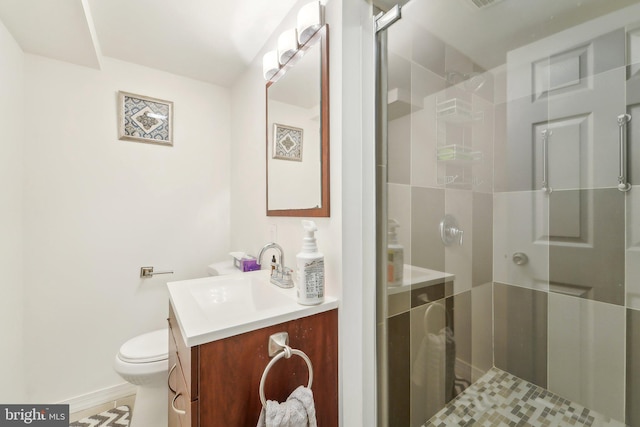 bathroom featuring vanity, a shower with shower door, and toilet